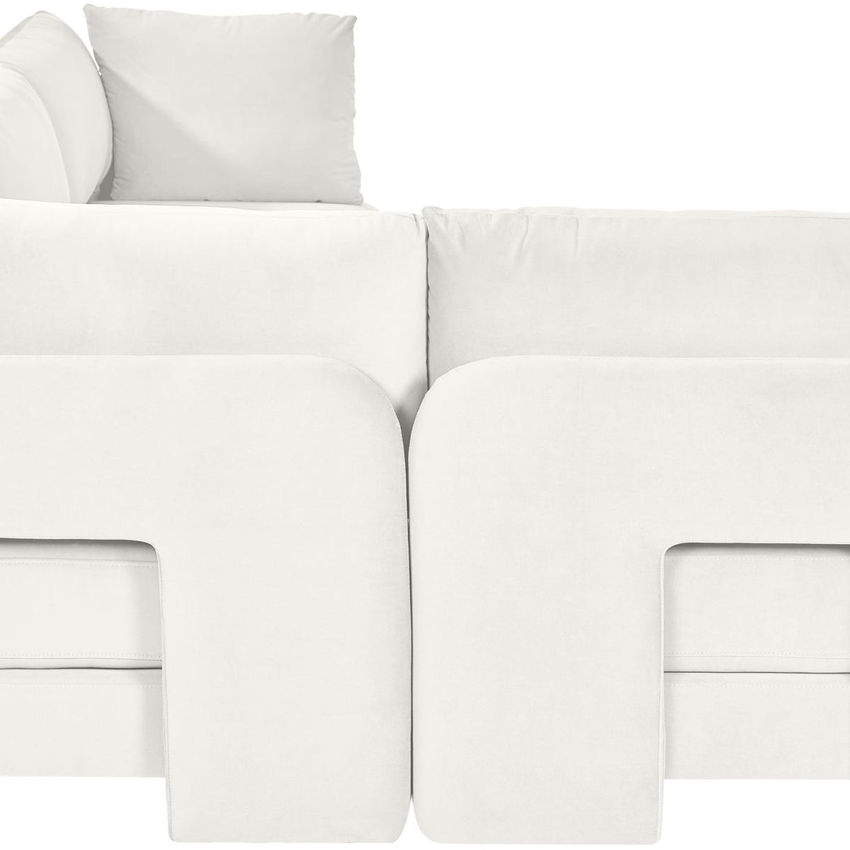 White velvet armless sectional sofa, close-up view of rounded arm panels