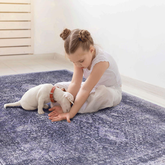 Blue washable area rug with distressed ornamental design, rectangular.