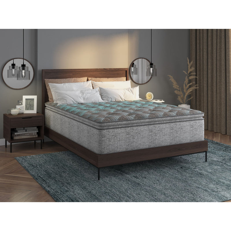 Dark gray plush hybrid mattress on bed frame with white pillow set
