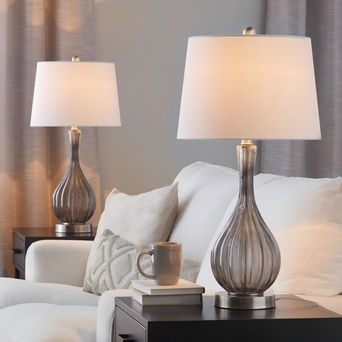 Set of 2 table lamps with white shades and clear glass urn bases, gold-toned hardware.