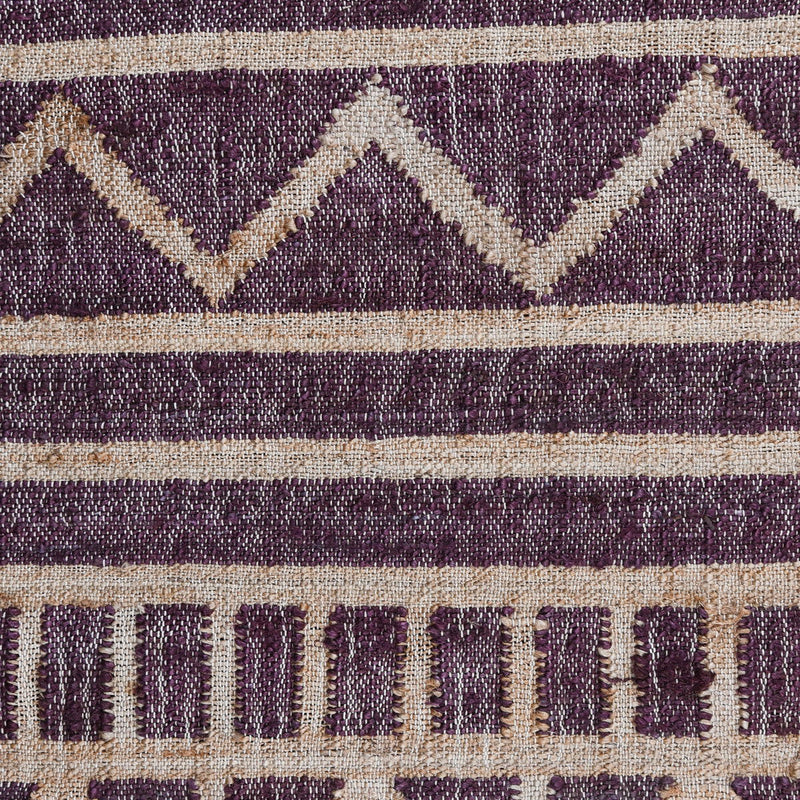 Close-up distressed rug with purple diamond pattern, cream stripes, and fringe