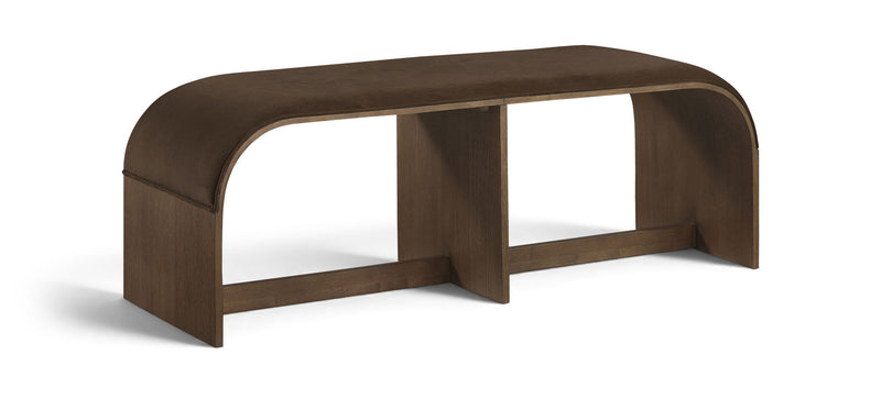 Dark brown velvet upholstered bench with curved top and open frame beneath