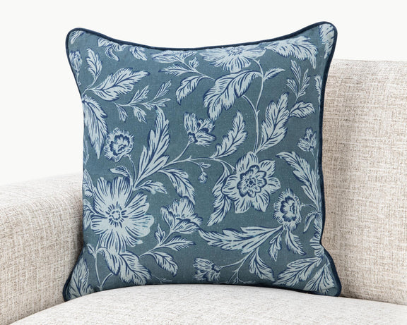 Blue floral square pillow with white botanical pattern and dark edge piping