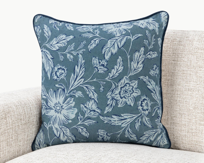 Blue floral square pillow with white botanical pattern and dark edge piping