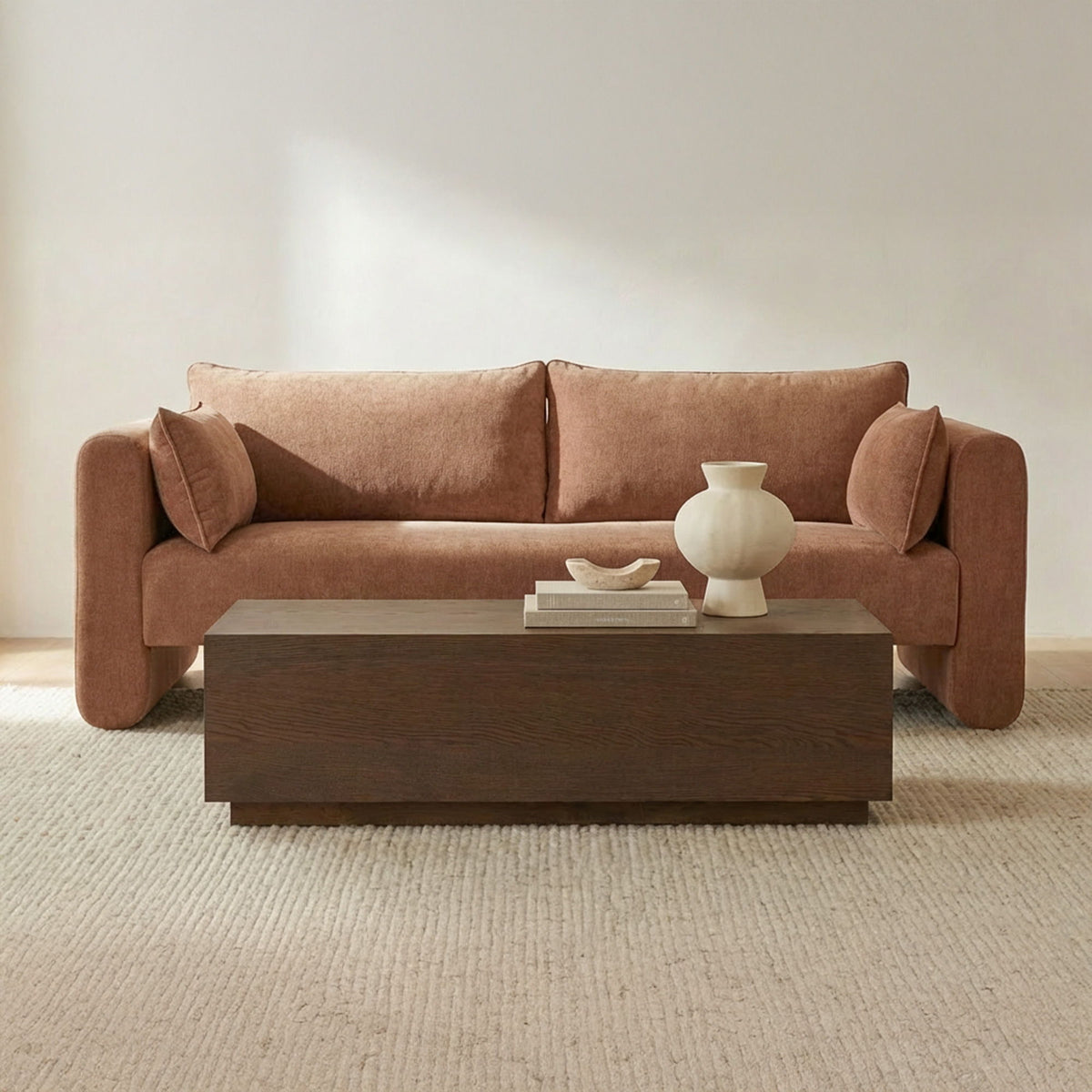 Dusty pink fabric sofa with two bolster cushions and deep cushioned seat