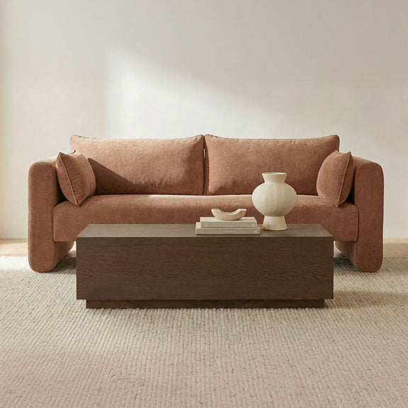 Dusty pink fabric sofa with two bolster cushions and deep cushioned seat