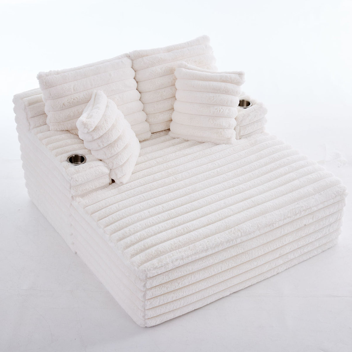 Oversized white chaise lounge chair with ribbed plush upholstery and decorative back pillows