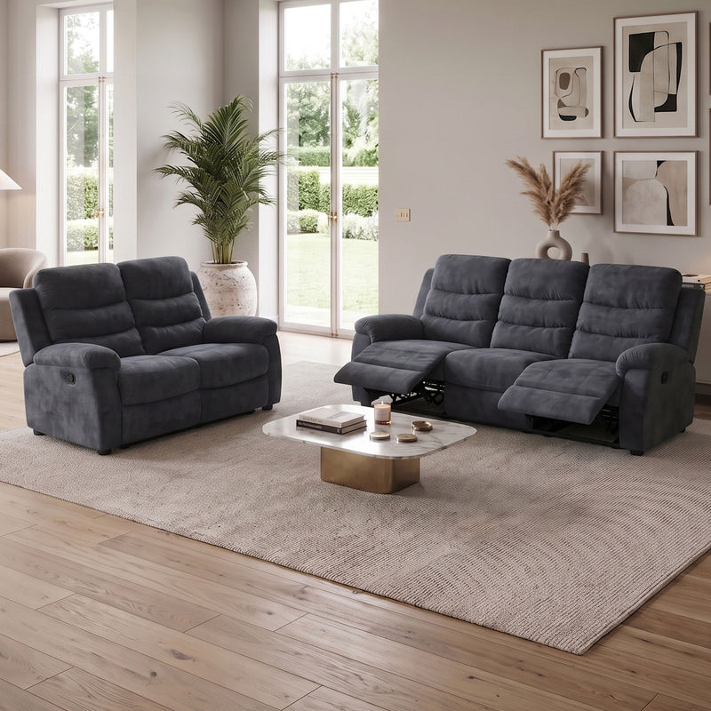Dark gray reclining sofa set with attached headrests, shown in a living room setting
