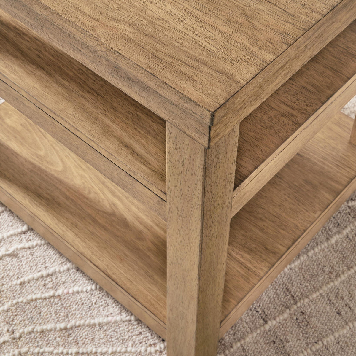Natural wood end table corner with visible wood grain and open shelf edge