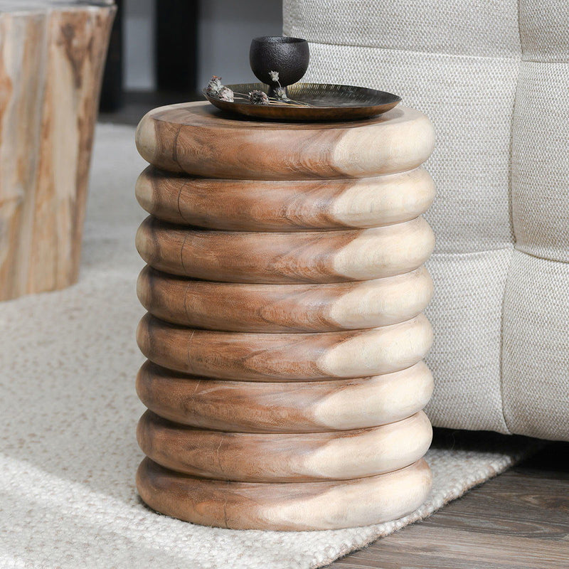 Natural round end table with stacked ring base and wood grain, top styled with decor
