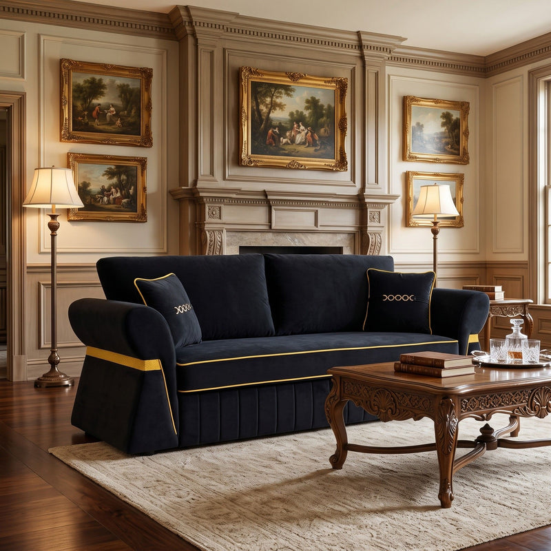 Three-seat dark navy sofa with gold piping, accent pillows, and pleated base