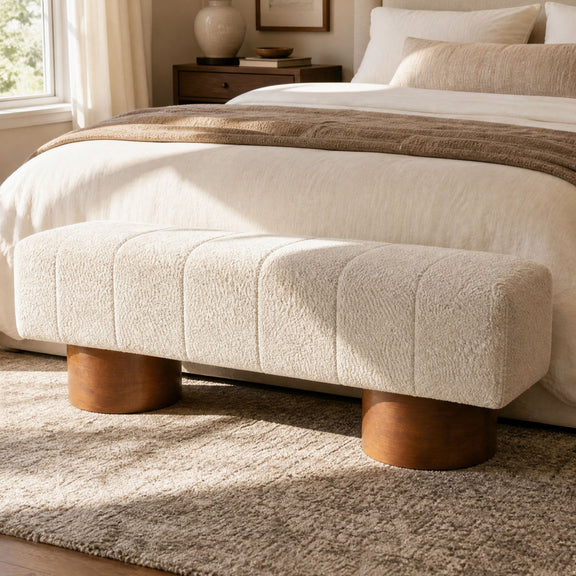 Beige upholstered dining bench with tufted seat and rounded wooden legs