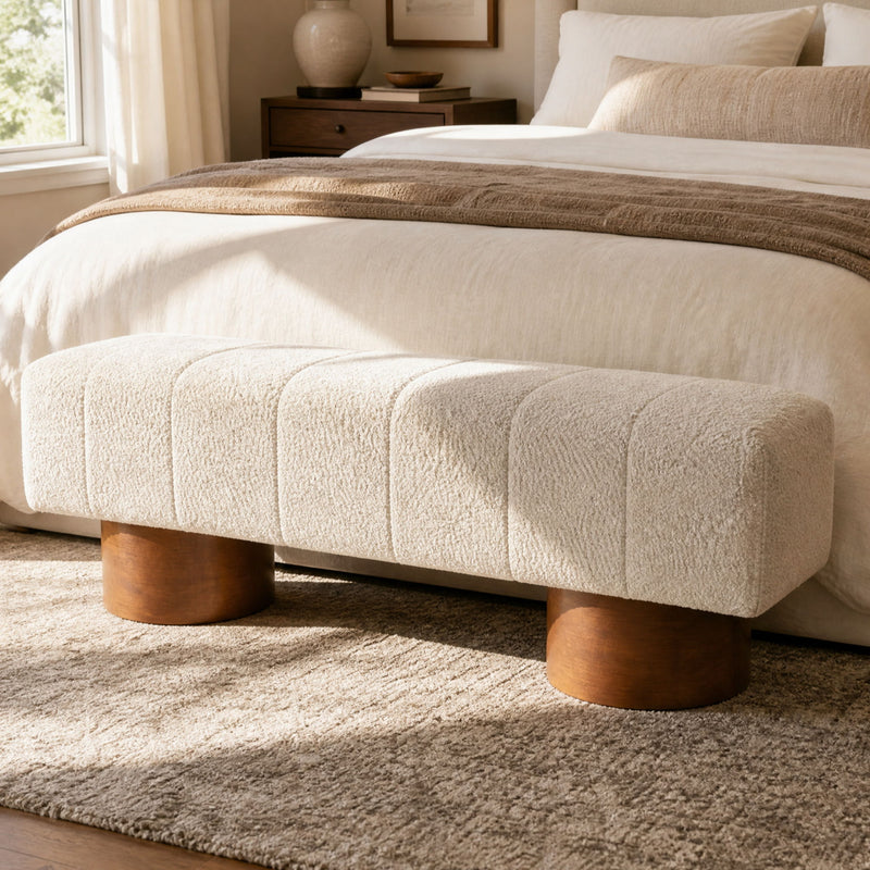 Beige upholstered dining bench with tufted seat and rounded wooden legs
