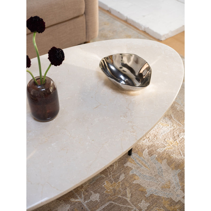 Beige stone coffee table corner with metal bowl and small vase centerpiece
