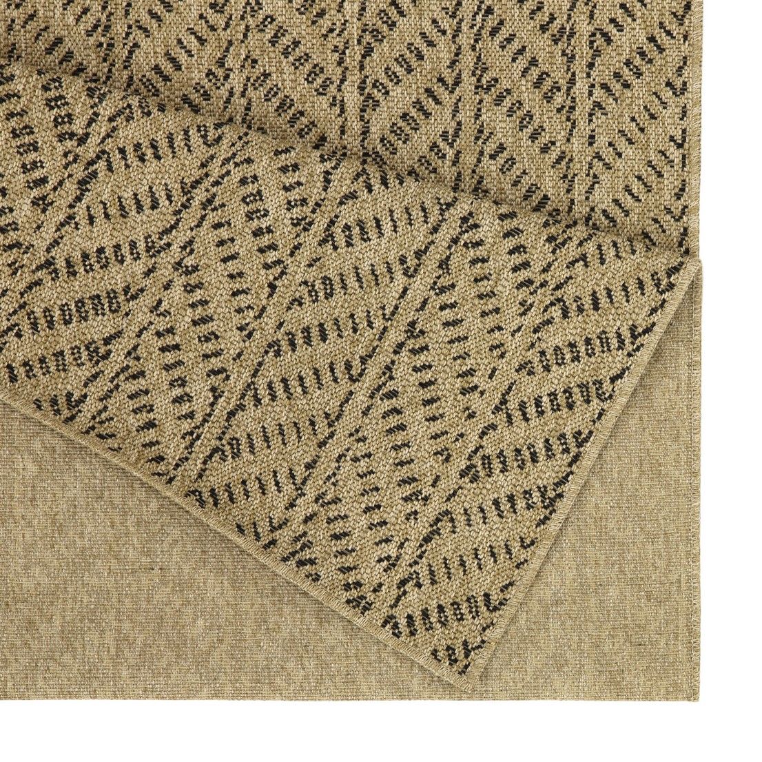 Light brown indoor/outdoor area rug close-up with dark dotted chevron pattern