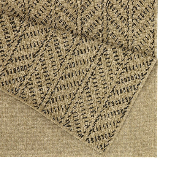Light brown indoor/outdoor area rug close-up with dark dotted chevron pattern