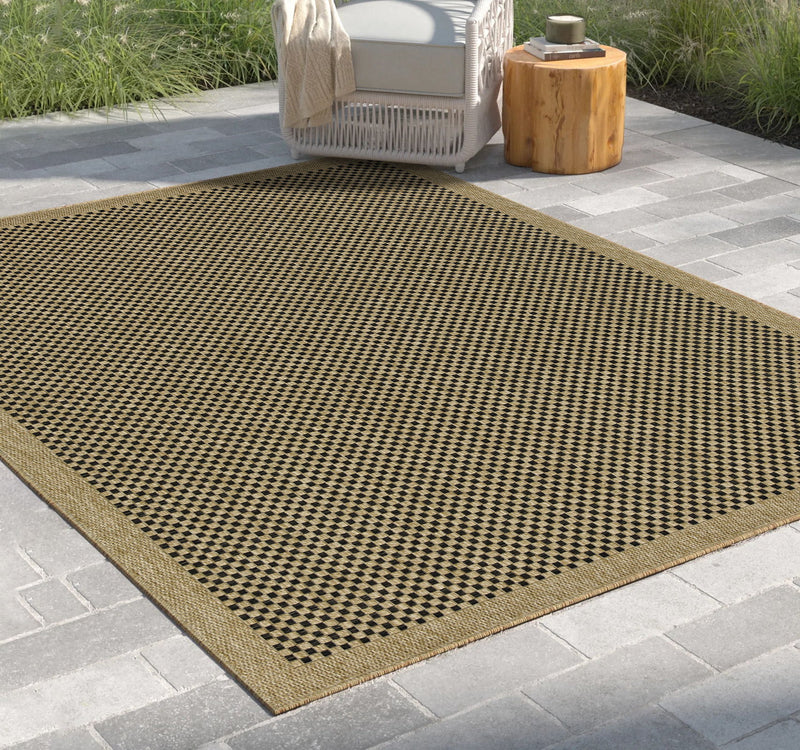 Light brown indoor-outdoor area rug with black-and-brown checkered pattern border