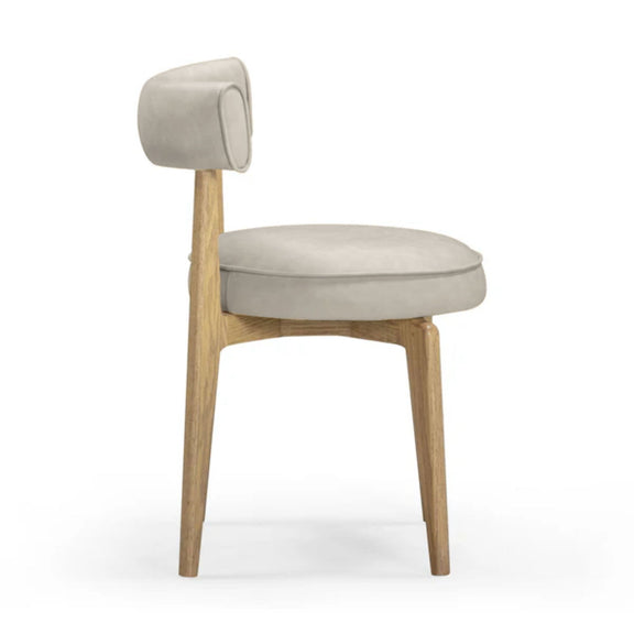 Beige dining chair with rounded backrest, oval seat cushion, light wood legs, 3/4 view.