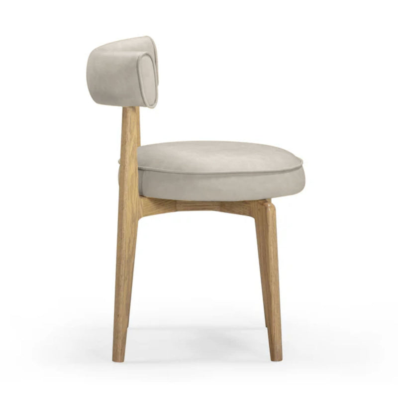 Beige dining chair with rounded backrest, oval seat cushion, light wood legs, 3/4 view.