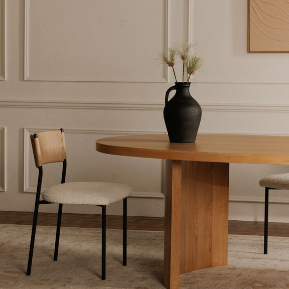 Foley dining chair with a white upholstered seat, woven tan back, and black metal frame