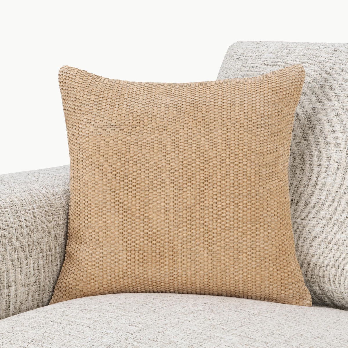 Tan woven square pillow on light upholstered seating