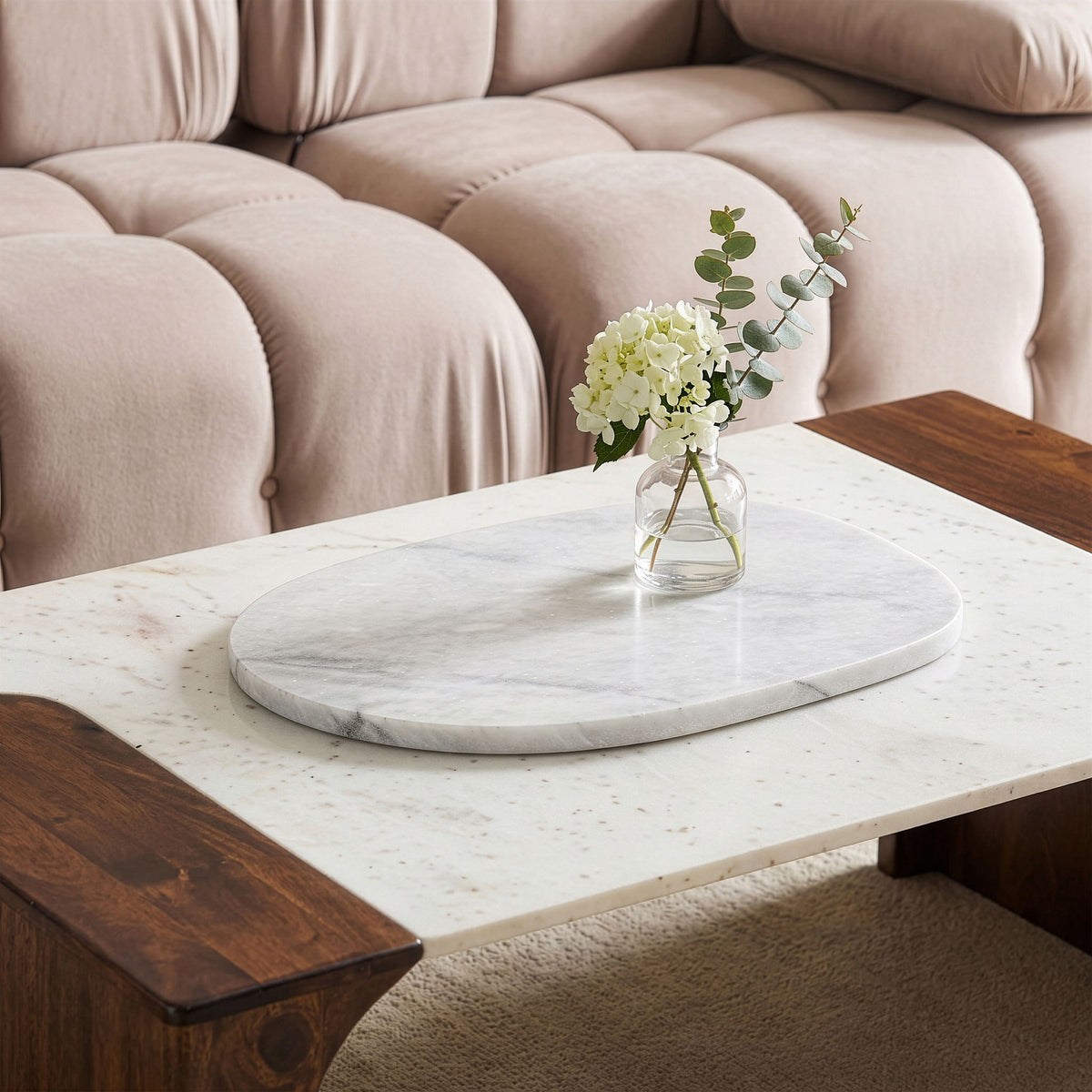 Round white marble decorative tray on a table with vase flowers in center