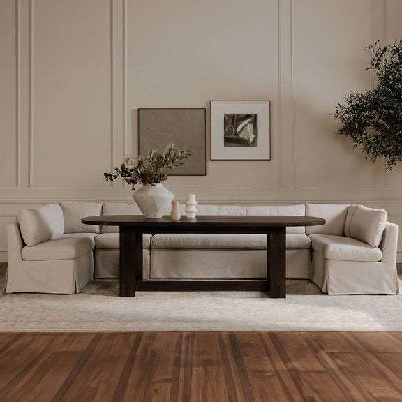 Beige slipcovered dining banquette sectional with multiple seat and back cushions
