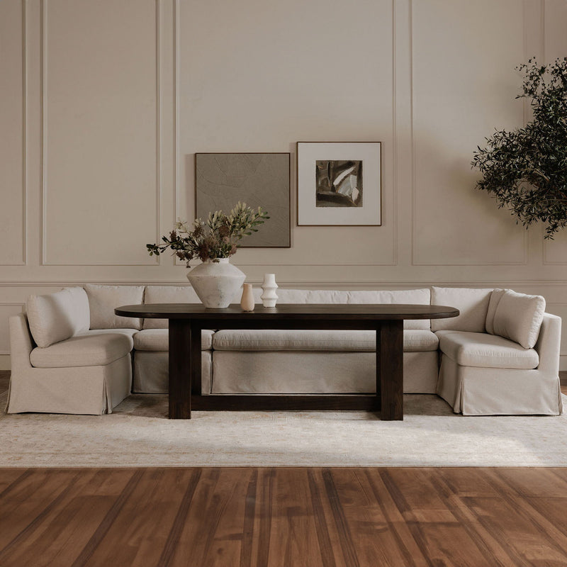 Beige slipcovered dining banquette sectional with multiple seat and back cushions