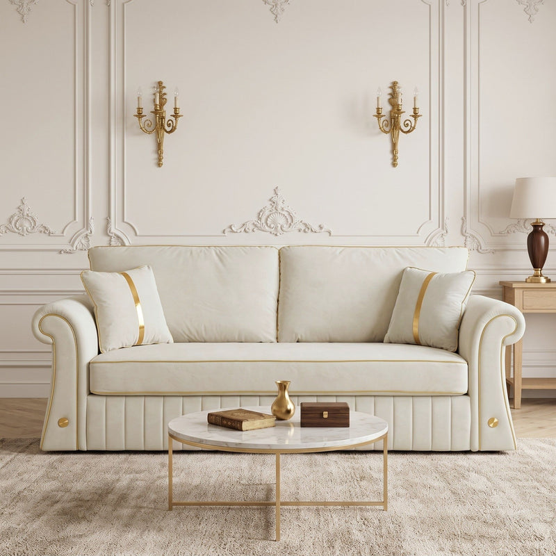 Front view of cream three-seat sofa with rolled arms, gold trim, and two pillows