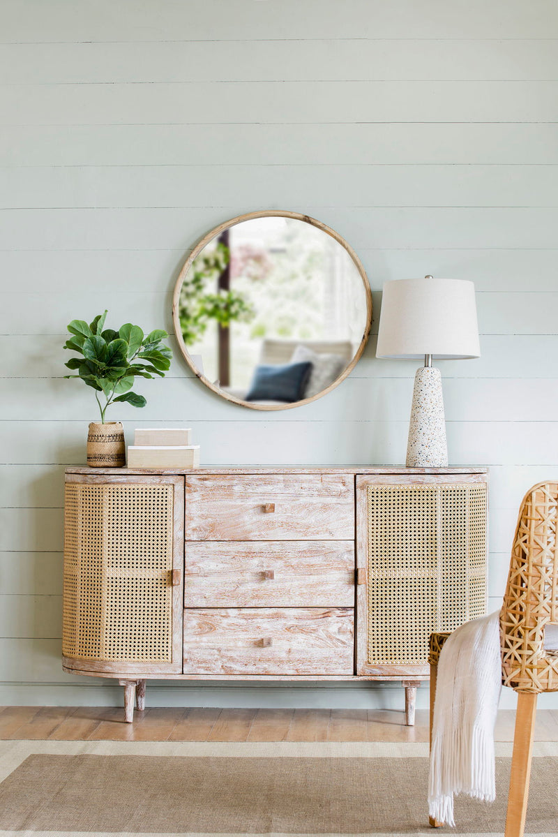 TV console with cane doors, three drawers, distressed pale wood finish, and tapered legs