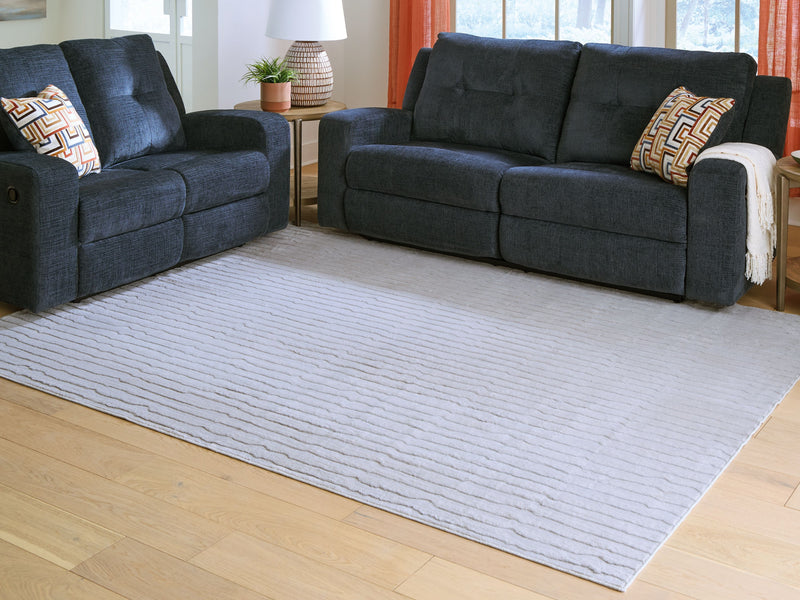 Light gray washable rug with thin wavy stripes and finished border