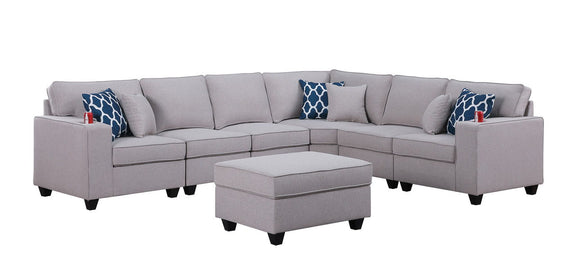 Gray sectional sofa with ottoman centerpiece and blue patterned accent pillows, wide view
