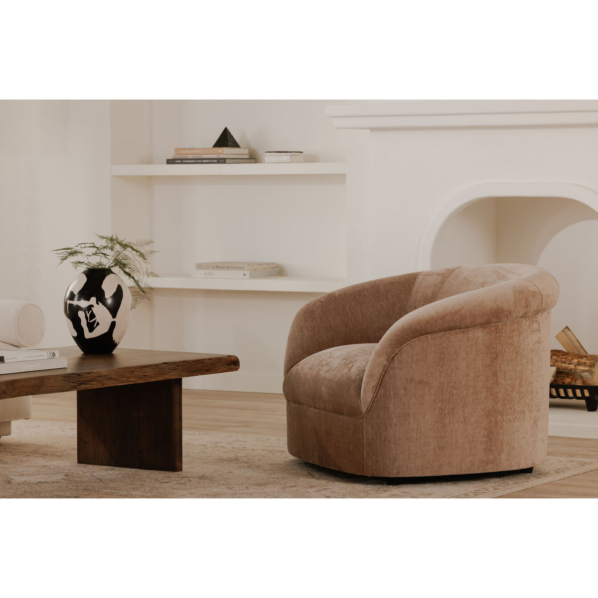 Blush barrel-style lounge chair with curved back and wide arms, upholstered fabric.