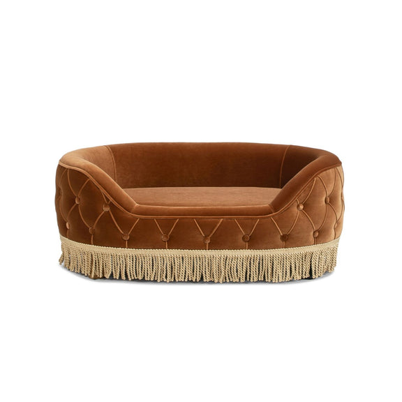 Burnt orange tufted dog sofa bed with fringed skirt and rounded cushioned sides