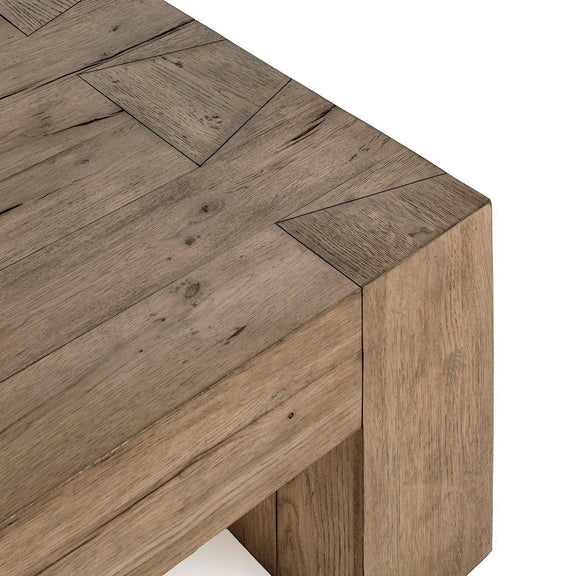 Reclaimed oak tabletop corner with visible grain and panel seams, dark brown