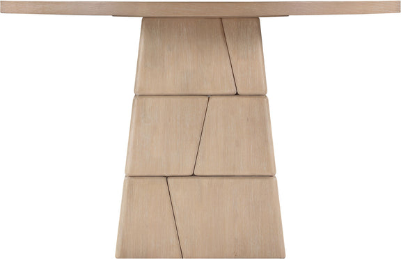 Light brown round dining table with stacked block pedestal base, close-up