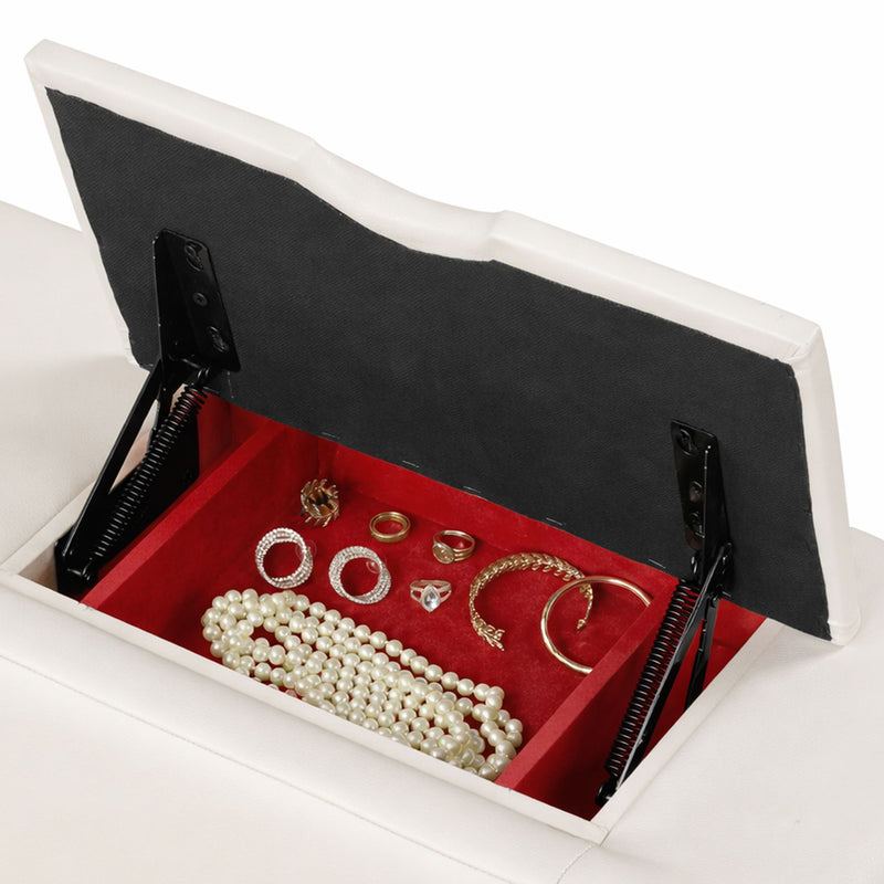 White massage bed with open hidden storage tray holding small accessories