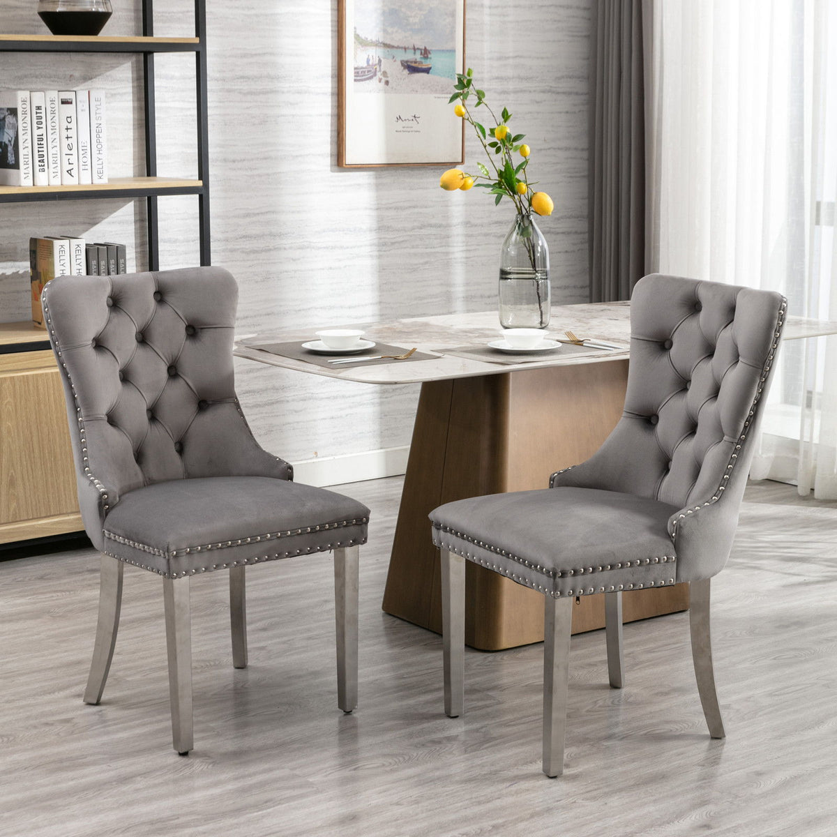 Gray tufted upholstered dining chair with nailhead trim and curved wooden legs