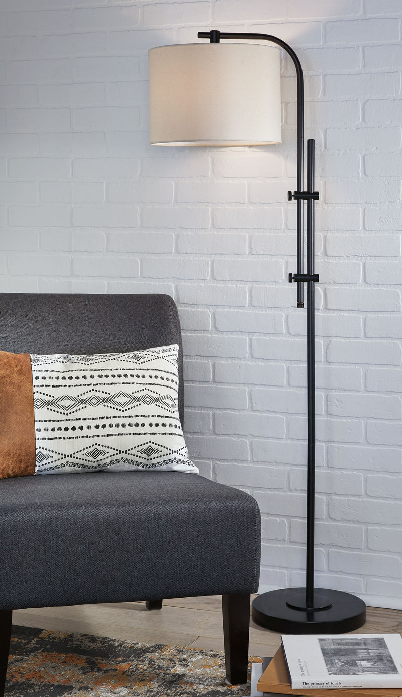 Black metal floor lamp with cream fabric drum shade and round weighted base.