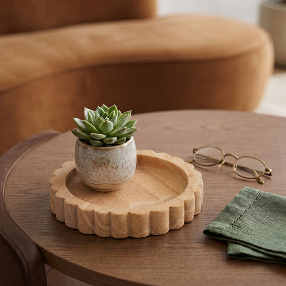 Sandstone tray on wooden table holding a small succulent pot, sand-colored scalloped rim