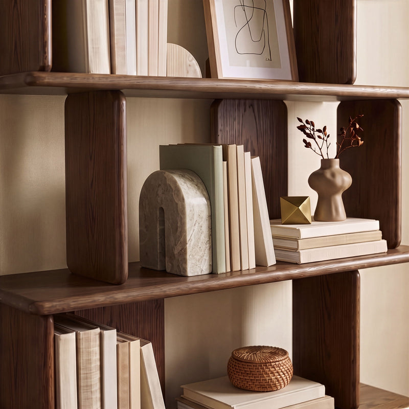 Beige marble bookend with arched cutout, shown on bookshelf