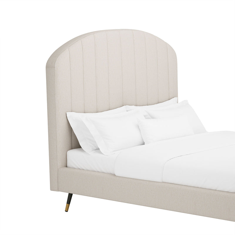 Beige arched upholstered headboard and platform bed with white bedding