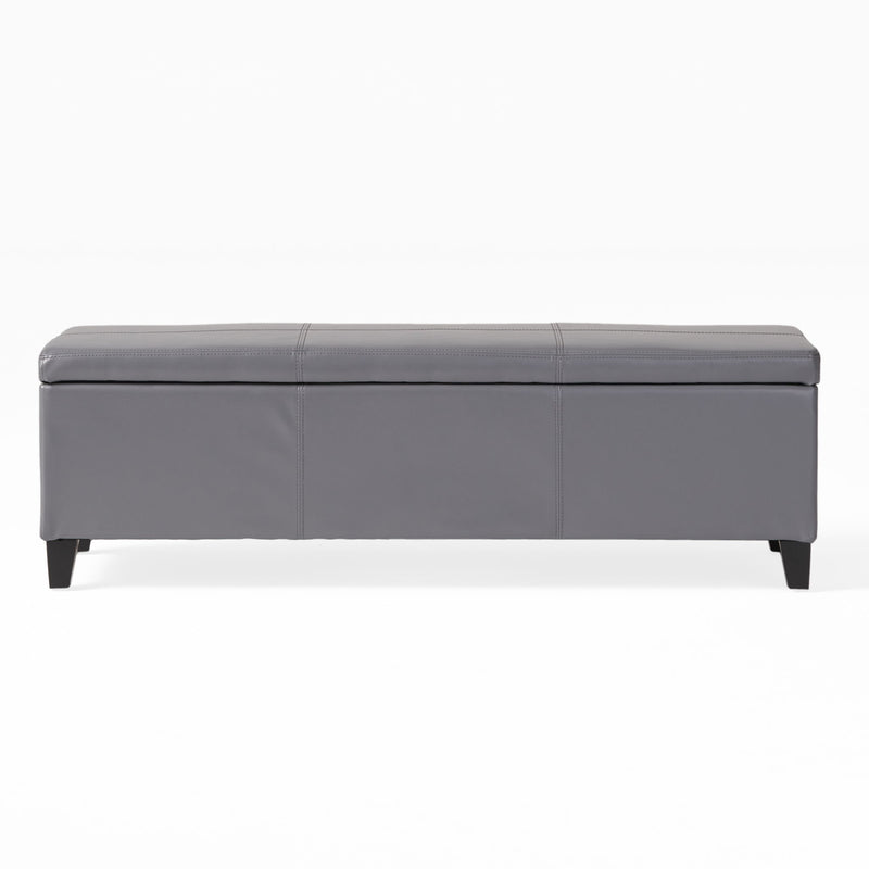 Dark gray storage ottoman with padded top, stitched paneling, and tapered legs