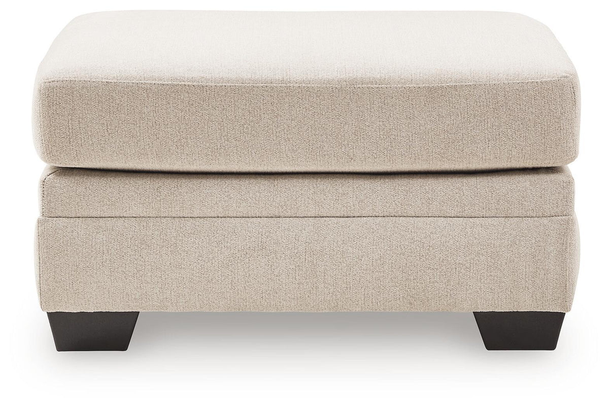 Beige accent ottoman with cushioned top and dark tapered block legs