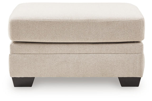 Beige accent ottoman with cushioned top and dark tapered block legs