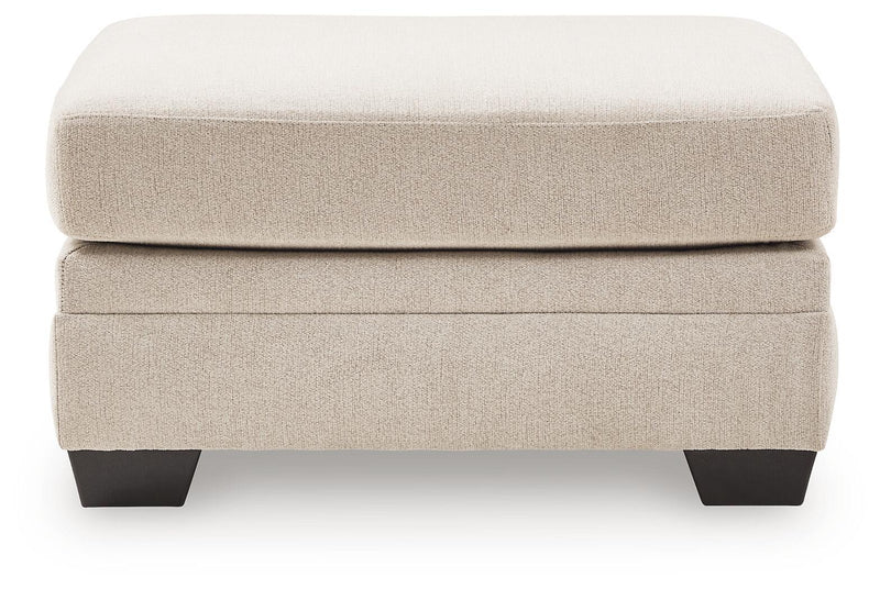 Beige accent ottoman with cushioned top and dark tapered block legs