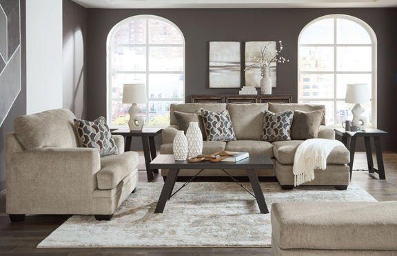 Taupe fabric sofa set with matching chaise chair and tufted accent ottoman in living room.