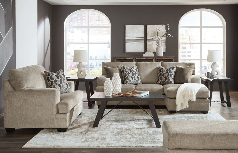 Taupe fabric sofa set with matching chaise chair and tufted accent ottoman in living room.