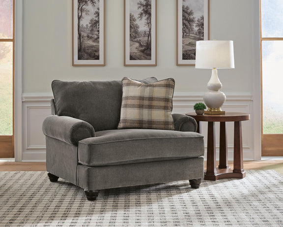 Shadow gray chair and a half with plaid lumbar pillow and padded armrests