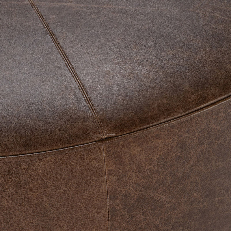 Close-up of brown leather upholstery seams and stitched panel line